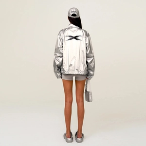 Giacca oversize argento metallizzato vista posteriore con logo X nero e accessori