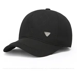Detail of black quilted winter baseball cap featuring a silver triangular metal logo badge