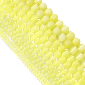 Macro shot of assorted yellow cat eye stone beads for DIY jewelry and crafts making