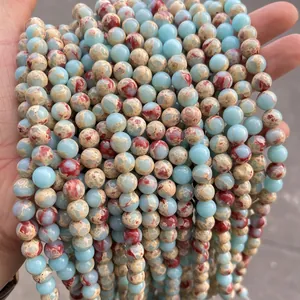 Strand of polished emperor stone round beads featuring blue and reddish brown patterns