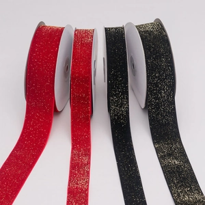 Close-up of red and black velvet ribbons with gold glitter for gift wrapping decoration