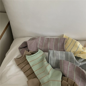 Pile of soft Morandi color striped crew socks in purple, yellow, and green tones
