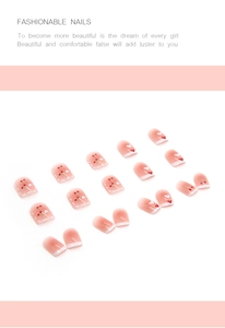Detail of pink gradient press-on nails with red cherry and white heart patterns