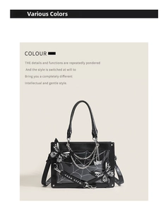 Detail of gothic black ita bag showing white spider web pattern and silver chain accents