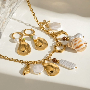 Golden necklace and hoop earrings set featuring starfish, shell, and pearl charms