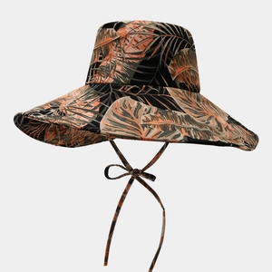 Détail d'un chapeau de soleil à larges bords avec imprimé palmier et mentonnière réglable