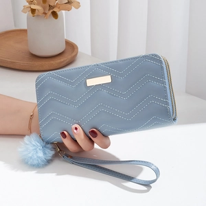 Women long pale blue wallet with V-shaped quilting, wrist strap and pompom charm