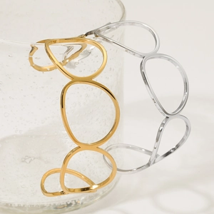 Minimalist oval open bangles in gold and silver finish on decorative glass