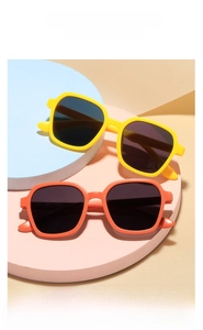 Detail view of yellow and orange square kids sunglasses with dark UV protection lenses