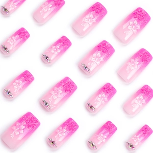 Pink gradient press-on nails with 3D white floral patterns and small rhinestones