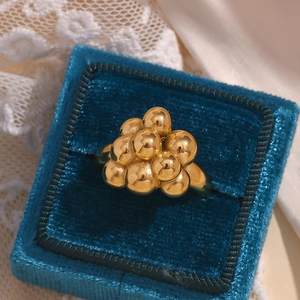 Macro shot of gold-plated bubble ring displayed in a luxury blue velvet jewelry box