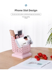 Detail view of pink plastic desk organizer with faux rattan texture and phone holder slot