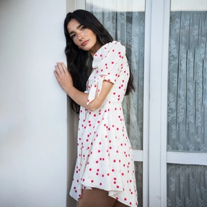 Détail de robe d'été blanche avec motif cerise rouge et manches courtes sur modèle