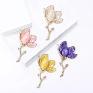 Elegant magnolia flower brooches in pastel enamel finishes with gold metallic accents