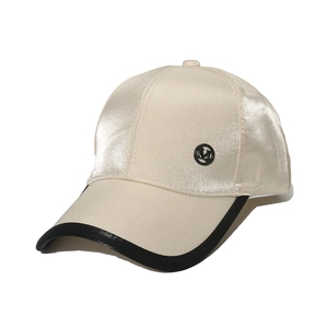 Beige satin baseball cap with black trim and metallic M logo in a minimalist design