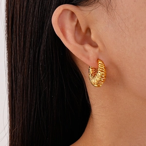 Detailed view of gold plated croissant dome hoop earrings with twisted spiral texture