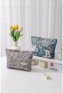 Detailed macro view of high-quality jacquard cosmetic bags in purple and blue floral patterns