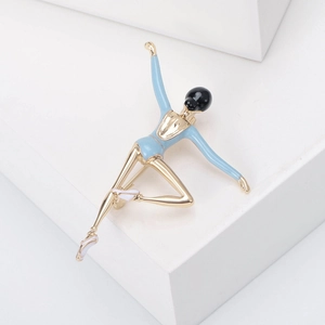 Detailed view of an elegant gold ballerina brooch with blue enamel and white ballet shoes