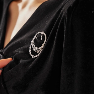 Vue macro d'une broche en zircon argenté avec étoile sur un vêtement en velours noir