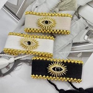 Details von gewebten Evil Eye Armbändern mit Goldperlen und verstellbaren Quasten