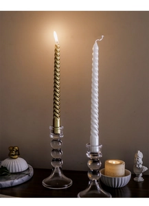 Dettaglio di candele a spirale in oro e bianco con portacandele in vetro sferici