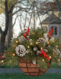Detail of hanging Christmas basket with frosted pinecones, red berries and warm LED lights