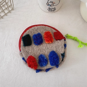 Close-up of soft plush bucket bag with colorful geometric blocks and red zipper detail