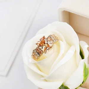 Macro shot of luxury gold ring with champagne zircon set in a white rose flower