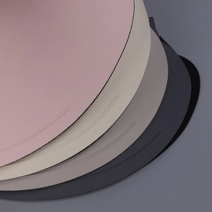 Detail showing high-quality round placemats with minimalist curved indentation and matte finish