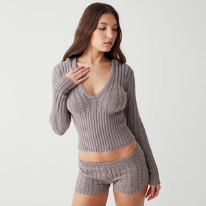 Detail der grauen Zopfstrickstruktur am langärmligen Kapuzenoberteil und Shorts