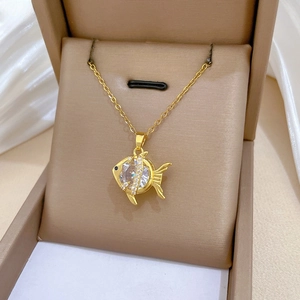 Macro shot of gold goldfish pendant with sparkling zircon inlay and delicate chain detail