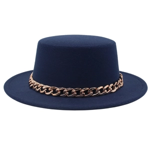 Dettaglio di cappello in feltro blu scuro con catena decorativa a maglie grandi oro rosa