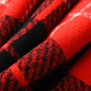 Detailed close-up of red and black plaid faux cashmere fabric with soft fuzzy texture