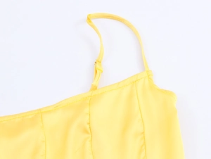 Detail of yellow satin camisole showing adjustable shoulder straps and fine stitching
