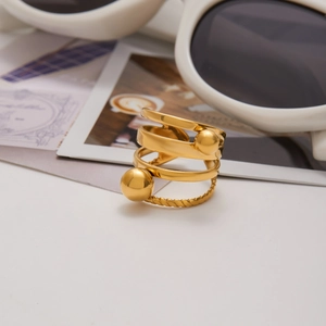 Makro-Detail des 18K Gold-Edelstahlrings mit Metallkugeln und gedrehter Textur