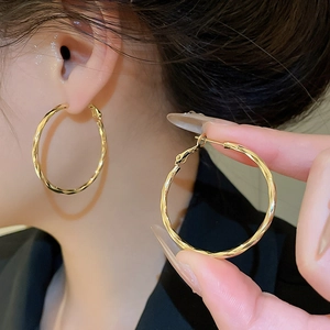 Detailed macro view of 14k gold plated twisted hoop earrings with elegant spiral texture