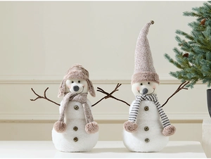 Detail of plush Christmas snowmen figurines with knitted hats and bells in festive setting