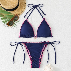 Navy blue halter bikini set with pink ruffle trim and gold pendant on white background