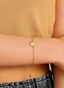 Détail du bracelet à breloque cœur doré avec gravure P porté au poignet pour style