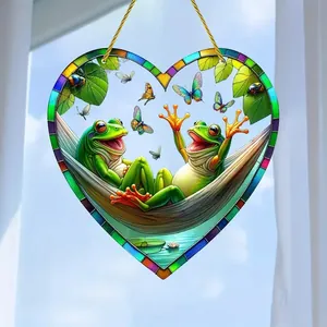 Close-up of heart-shaped acrylic suncatcher with colorful frogs and butterflies print