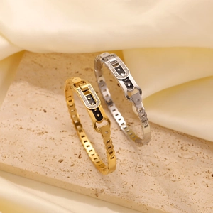 Detail of gold and silver butterfly hollow bracelets with zircon inlay on stone and silk