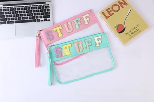 Detail of transparent PVC makeup bags with STUFF letter patches and matching wristlets