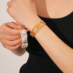 Detailed view of hollow mesh cuff bracelets in gold and silver plating on model