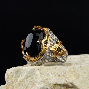 Macro detail of vintage two-tone ring with black gemstone on natural stone base