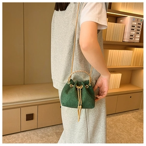 Detailed shot of dark green rhinestone bucket bag with golden ring handle and chain