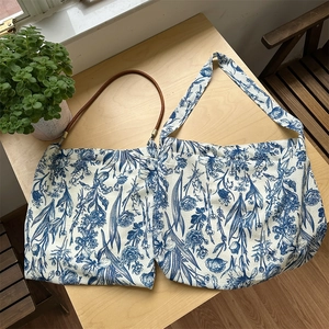 Detail of vintage blue floral cotton tote bags with brown handles and wide shoulder straps