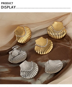 Macro detail of gold and silver seashell jewelry sets with cubic zirconia on ceramic