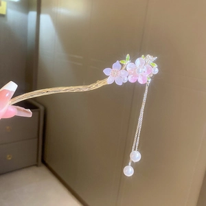 Détail d'épingle à cheveux fleur rose avec glands de perles et tige dorée