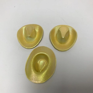 Primo piano di tre mini cappelli da cowboy dorati per decorazioni di feste e artigianato