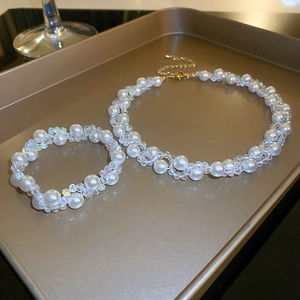 Detail view of French retro pearl and crystal necklace set on a luxury gold tray